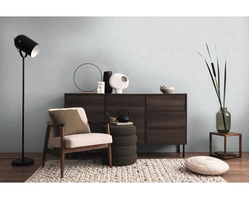 Woonkamer met dressoir, fauteuil, vloerlamp en decoratieve elementen voor een gezellige sfeer