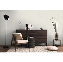 Woonkamer met fauteuil, dressoir, staande lamp en decoratie voor een huiselijke sfeer.