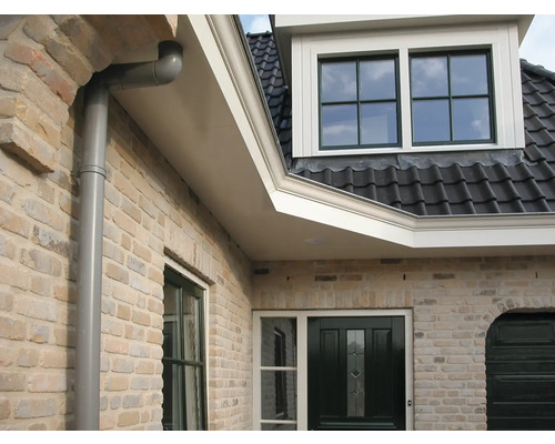 Gevel van een huis met dakkapel, dakgoot en bakstenen