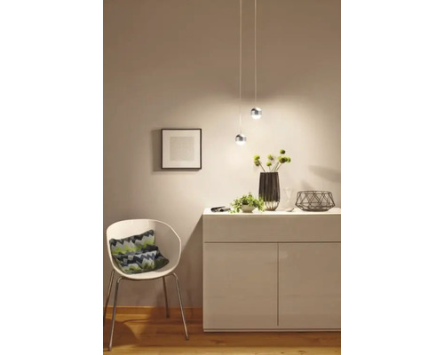 Licht interieur met dressoir, stoel en hanglampen voor een vriendelijke sfeer.