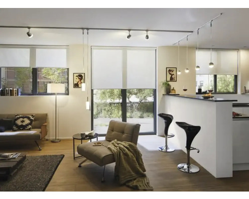 Lichte woonkamer met bank, fauteuil, rolgordijnen en verlichtingssysteem