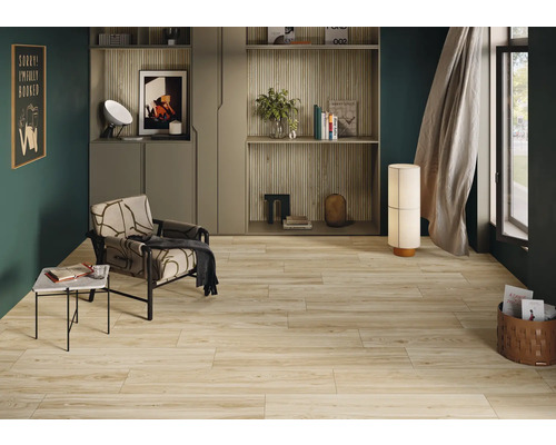 Woonkamer met lichte houten vloertegels, fauteuil en rekken