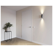 Lichte ruimte met deur, wandlamp en decoratie op een tafel