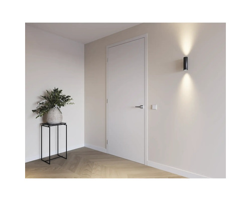 Lichte ruimte met deur, wandlamp en decoratie op een tafel