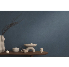 Blauw vliesbehang in woonkamer met decoratie op een houten tafel.