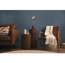 Woonkamer met bank, fauteuil, bijzettafels en decoratie voor een blauwe wand