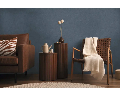 Woonkamer met bank, fauteuil, bijzettafels en decoratie voor een blauwe wand