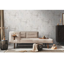 Woonkamer met beige bank, decoratieve wand en woonaccessoires