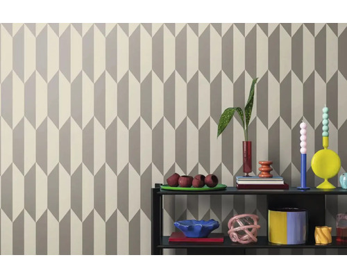 Wand met geometrisch behang en decoratieve objecten op een plank