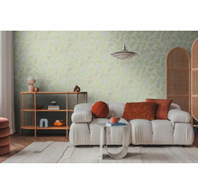 Lichte woonkamer met bank, rek en wandbehang met bladerpatroon