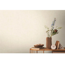 Decoratieve scène met bloemen, boeken en een tafelklok op een bijzettafel tegen een wand