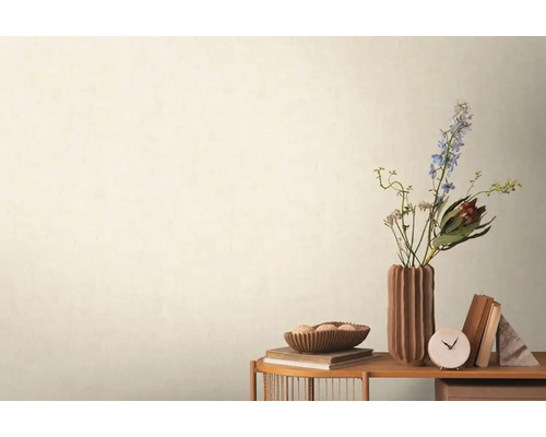 Decoratieve scène met bloemen, boeken en een tafelklok op een bijzettafel tegen een wand