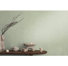 Decoratieve scène met vaas, takken en diverse objecten op een tafel voor een muur