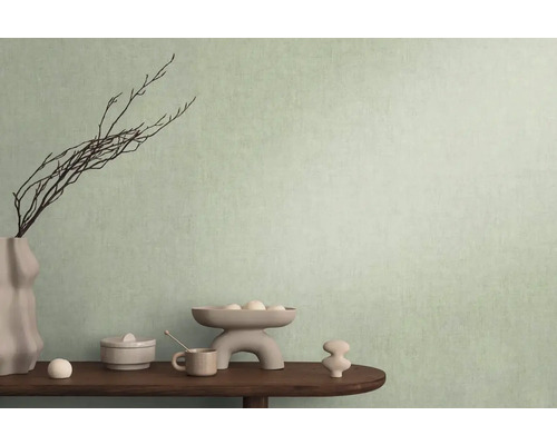 Decoratieve scène met vaas, takken en diverse objecten op een tafel voor een muur