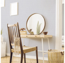 Decoratieve scène met een bureau, stoel, spiegel en accessoires in een lichte ruimte.