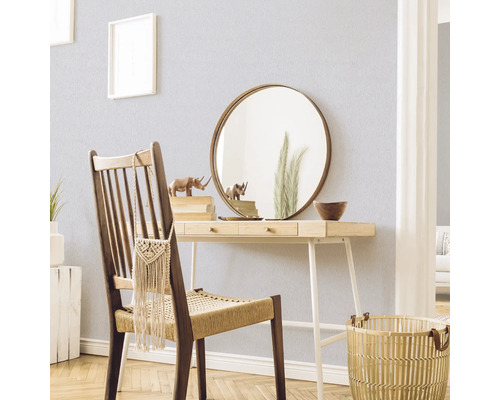 Decoratieve scène met een bureau, stoel, spiegel en accessoires in een lichte ruimte.