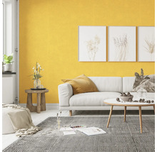 Woonkamer met witte bank, gestreept tapijt en gele muur