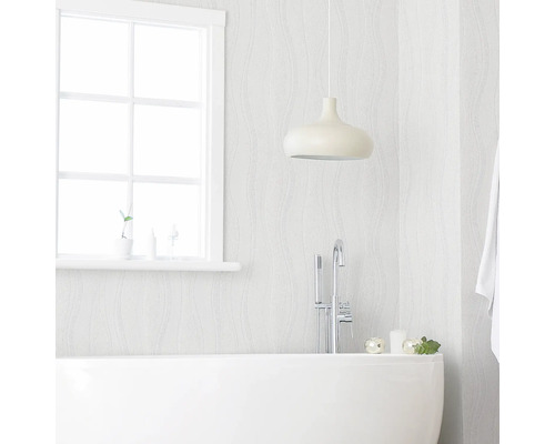 Badkamer met bad, kraan, hanglamp en raam