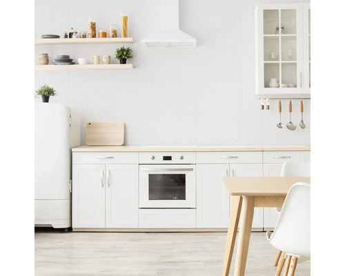 Lichte keuken met keukenkasten, planken, afzuigkap, eettafel en koelkast