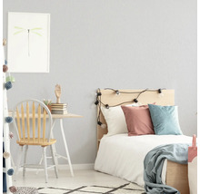 Lichte slaapkamer met bureau, stoel en bed.
