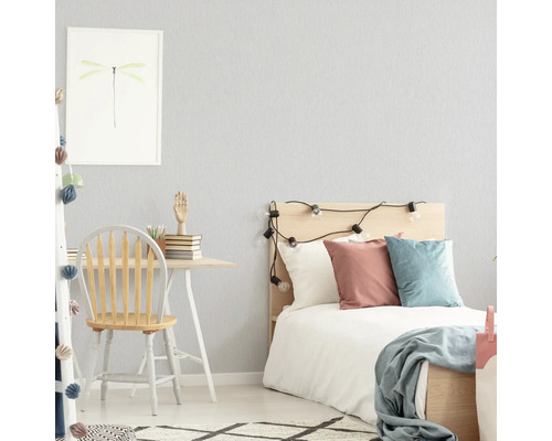 Lichte slaapkamer met bureau, stoel en bed.