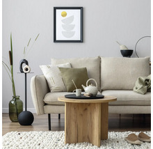 Woonkamerscène met bank, salontafel, decoratie en kunstwerk aan de muur voor een gezellige sfeer.