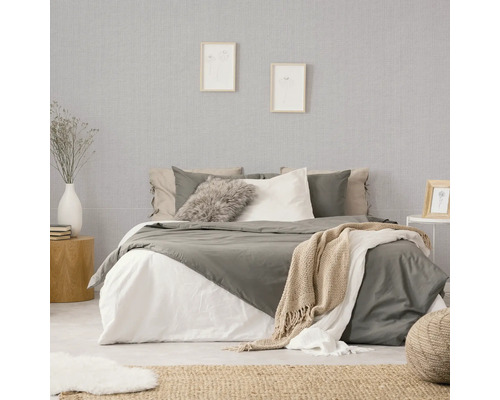 Slaapkamer met bed, nachtkastje en behang met patroon