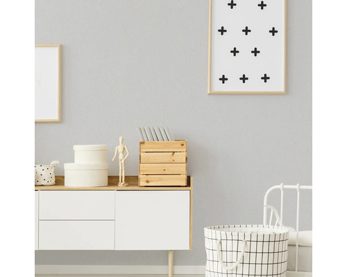 Lichte kamer met ladekast, decoraties en wasmand