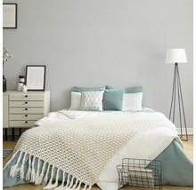 Slaapkamer met bed, nachtkastje en staande lamp