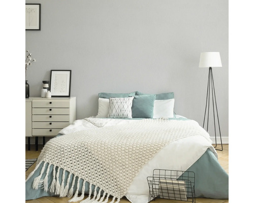 Slaapkamer met bed, nachtkastje en staande lamp