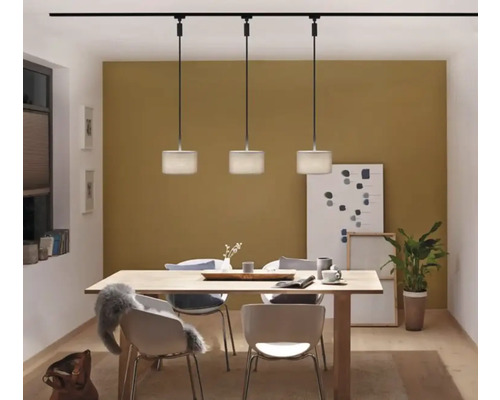 Eetkamer met eettafel, stoelen en een lichtinstallatie met drie hanglampen