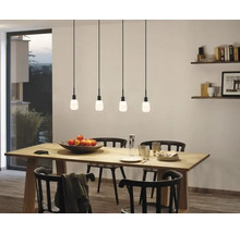 Eetkamer met houten tafel, zwarte stoelen en vier hanglampen