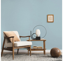 Woonkamer met fauteuil, bijzettafel, decoratie en vloerkleed
