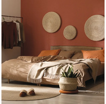 Slaapkamer met bed, wanddecoraties en planten