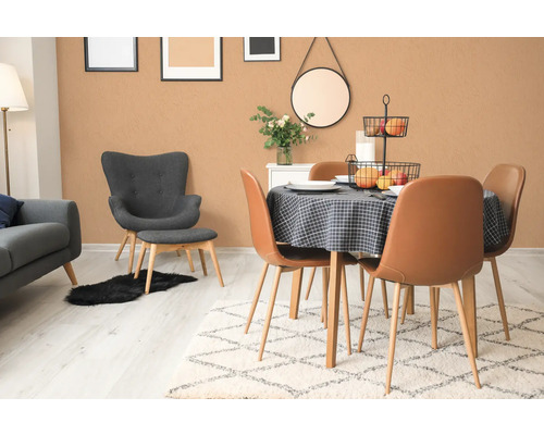 Lichte eetkamer met eettafel, stoelen, tapijt en decoratieve elementen.