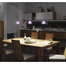 Eettafel met stoelen en hanglampen in een modern keukenontwerp.