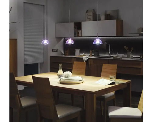 Eettafel met stoelen en hanglampen in een modern keukenontwerp.