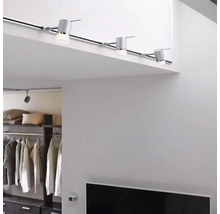 Interieur met railverlichtingssysteem aan het plafond en een rekkensysteem op de achtergrond.