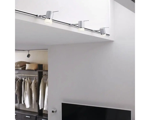 Interieur met railverlichtingssysteem aan het plafond en een rekkensysteem op de achtergrond.