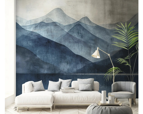 Woonkamer met behang van een berglandschap, een bank, een fauteuil en een staande lamp