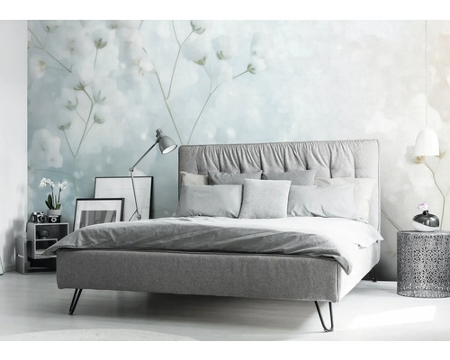 Slaapkamer met bed, nachtkastje en bloemenbehang