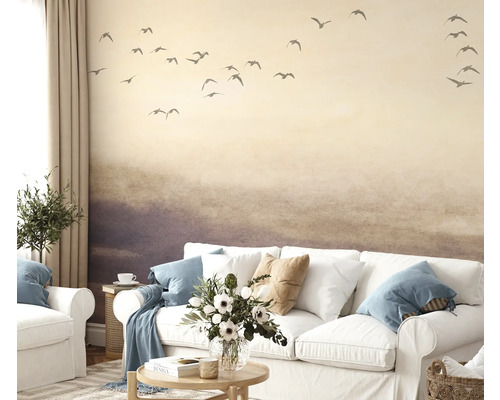 Woonkamer met behang dat een landschap met vogels voorstelt, bank en decoratie