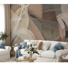 Woonkamer met abstract bladerpatroon op de muur achter een witte bank.