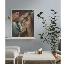 Woonkamer met foto van een stel, tafel, plant en lamp