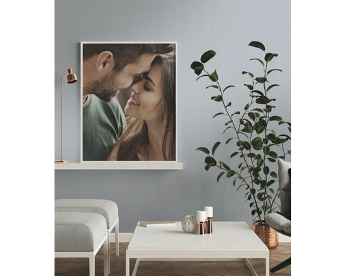 Woonkamer met foto van een stel, tafel, plant en lamp