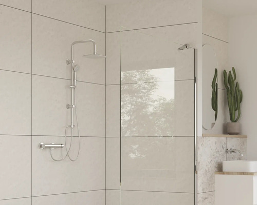 Badkamer met douchegarnituur, douchewand en wastafel