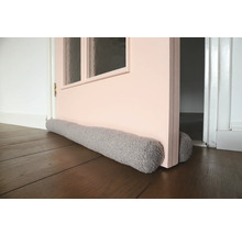 Tochtstopper voor een deur op een houten vloer.