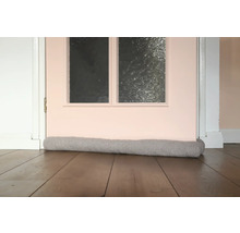 Tochtstopper voor een deur op een houten vloer