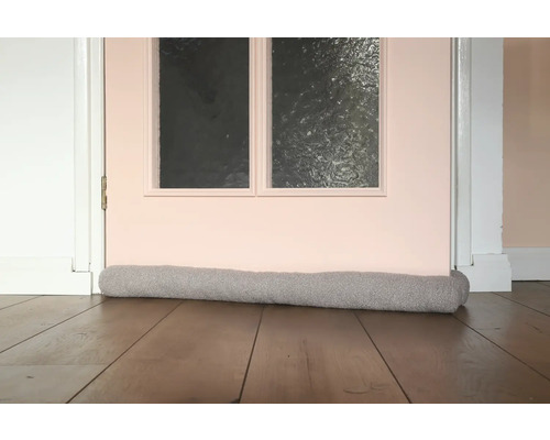 Tochtstopper voor een deur op een houten vloer