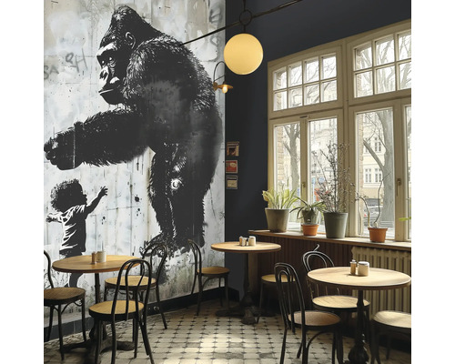 Interieur van een café met een muurschildering van een gorilla en een kind, tafels en stoelen.